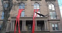 Photo of Cooper Union building with big red streamers flowing out of the windows