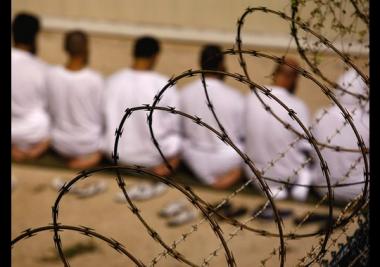 Close Guantanamo Photo of prisoners behind a barbed wire fence