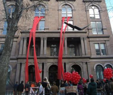 Photo of Cooper Union building with big red streamers flowing out of the windows